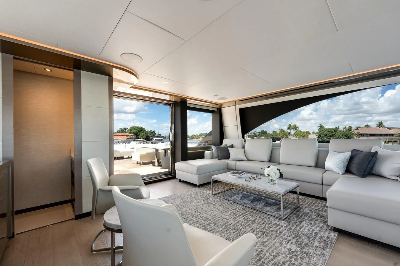 The salon offers a spacious and luxurious seating area with modern decor and large windows for panoramic views. aboard CHAOS Yacht for Sale
