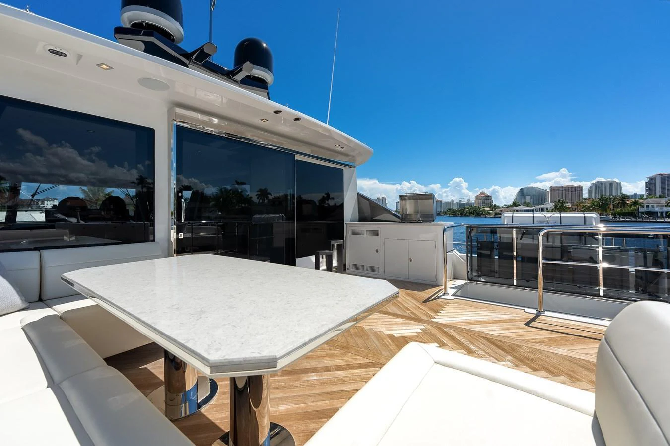 The aft deck features a spacious seating area with a sleek table, perfect for outdoor dining and relaxation. aboard CHAOS Yacht for Sale