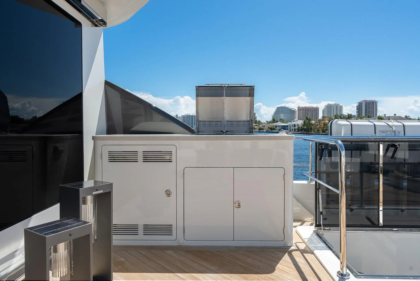 The yacht features a sleek outdoor galley with modern appliances and a stunning waterfront view. aboard CHAOS Yacht for Sale