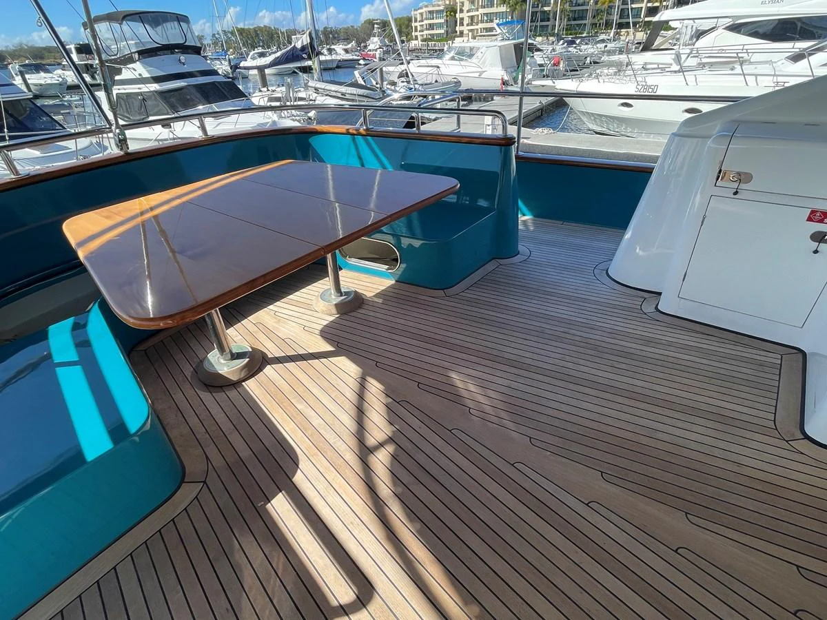 The aft deck features a spacious seating area with a wooden table, perfect for alfresco dining. aboard SV TEAL Yacht for Sale