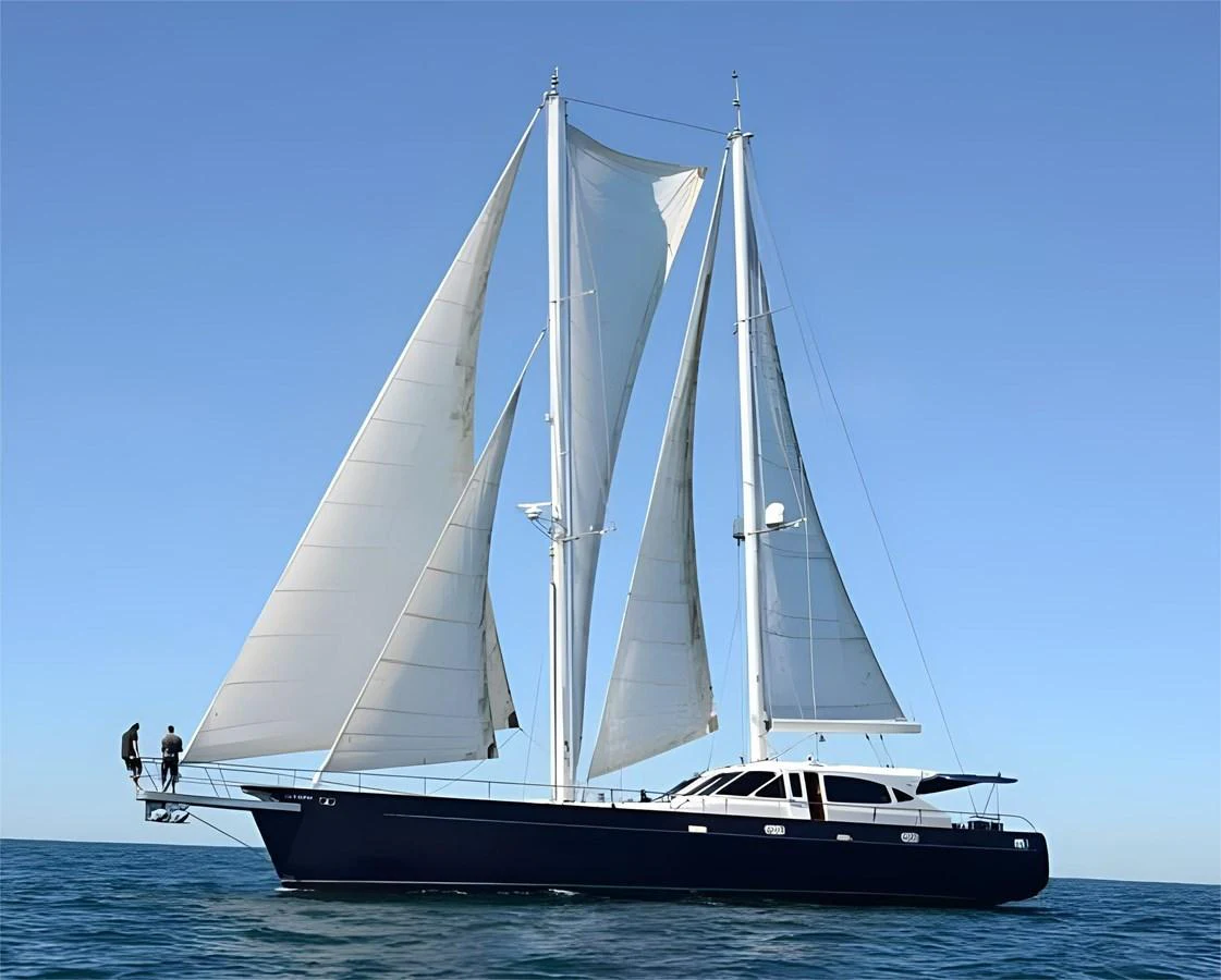 A sleek sailing yacht glides gracefully on the open sea under full sail. aboard SV TEAL Yacht for Sale