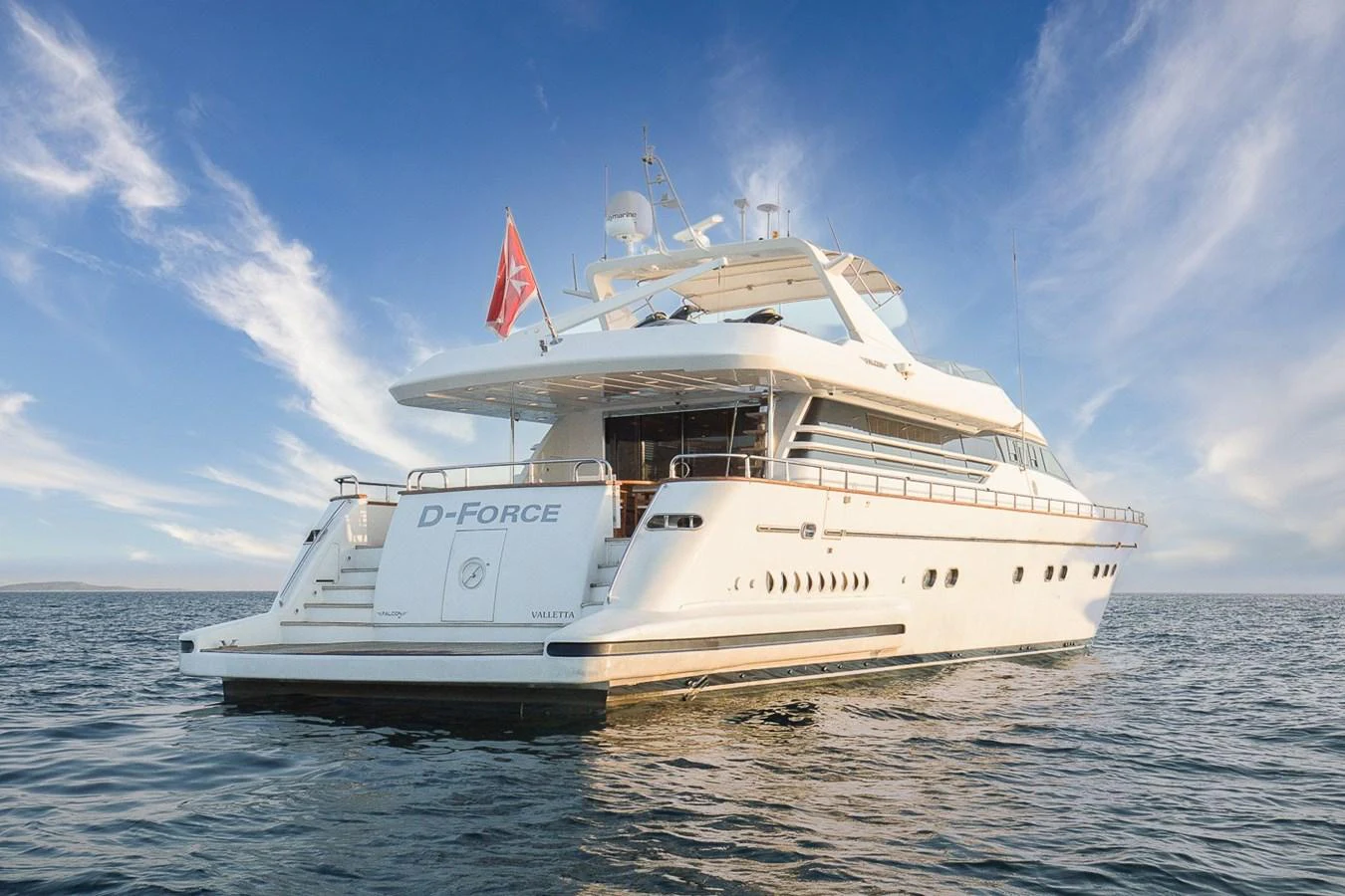 A luxurious yacht glides gracefully on calm waters under a clear sky. aboard D-FORCE Yacht for Sale