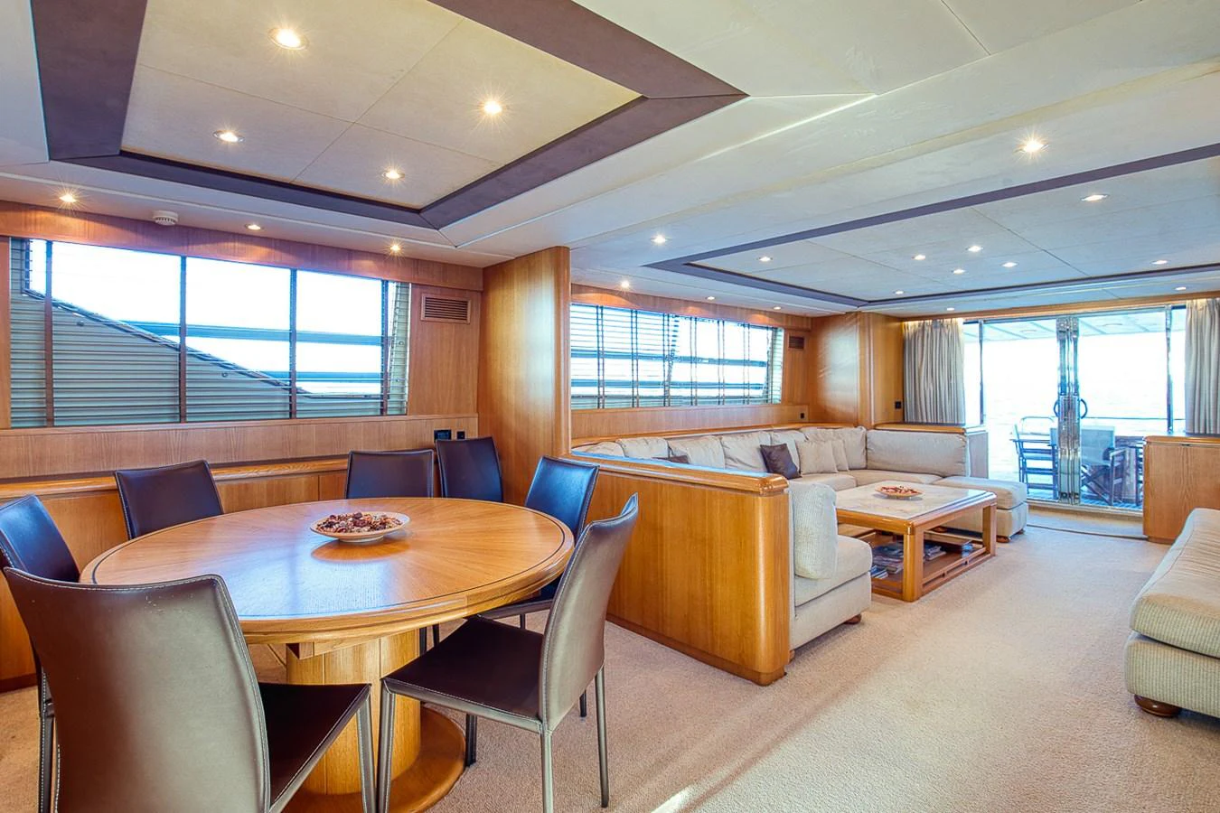 The spacious salon features a comfortable seating area and a dining table, perfect for entertaining guests. aboard D-FORCE Yacht for Sale