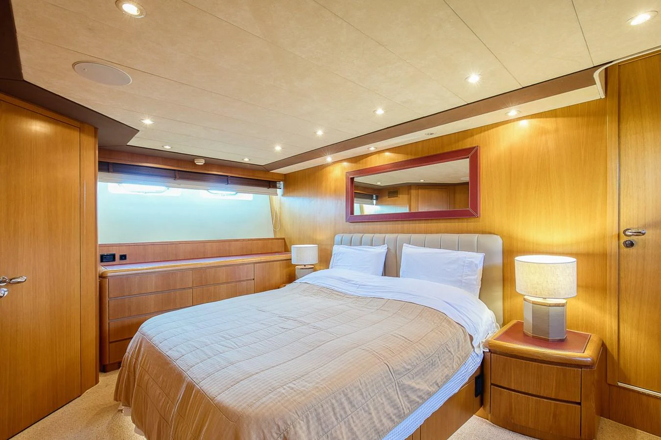 The stateroom features a cozy bed with elegant wooden furnishings and soft lighting. aboard D-FORCE Yacht for Sale