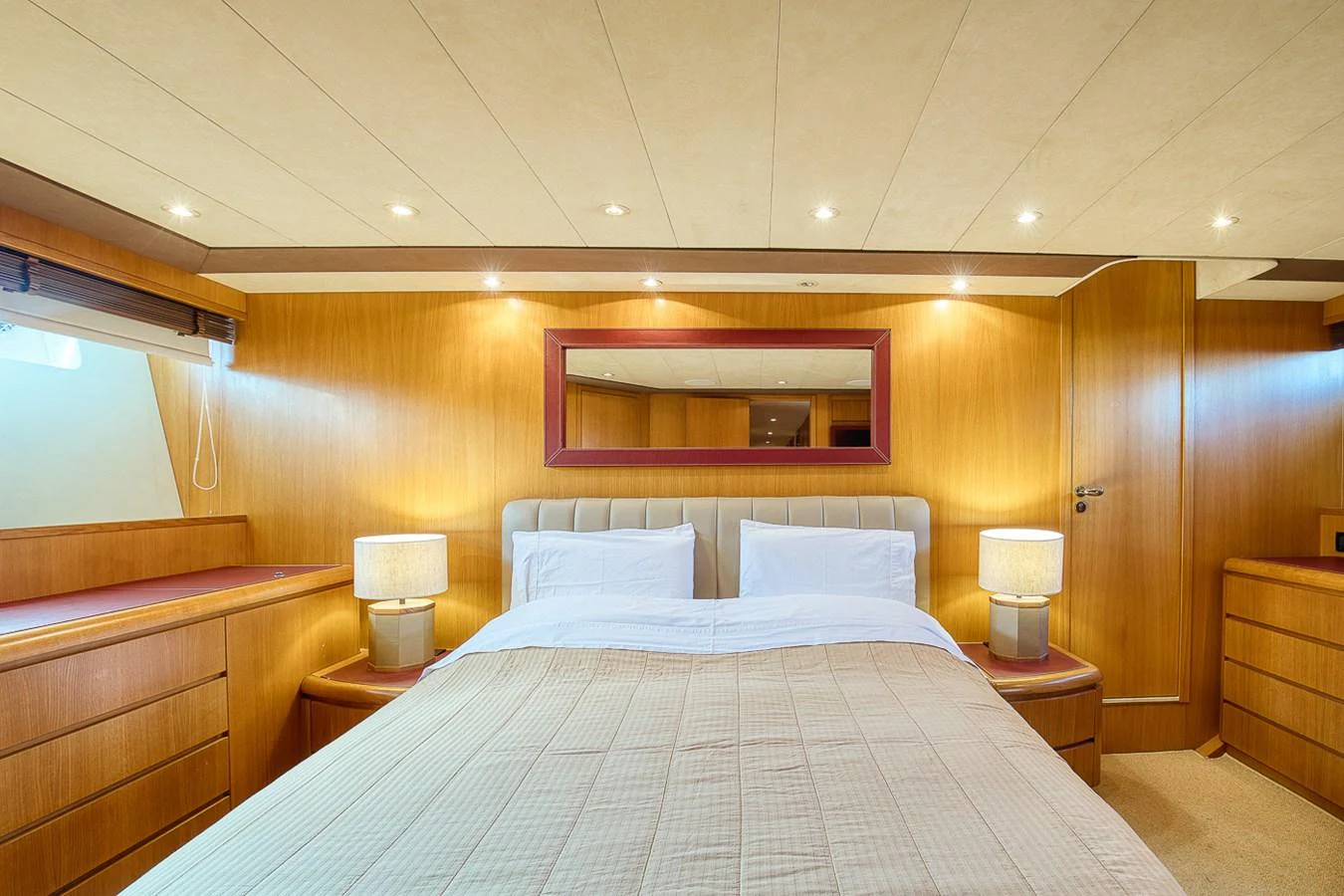 The master stateroom features a luxurious bed with elegant wood paneling and ambient lighting. aboard D-FORCE Yacht for Sale