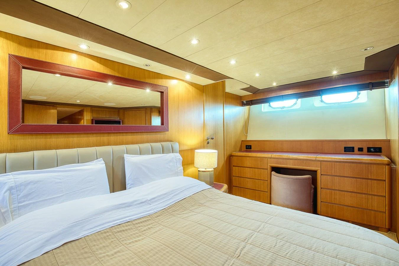 The stateroom features a comfortable bed, ample lighting, and elegant wood finishes. aboard D-FORCE Yacht for Sale