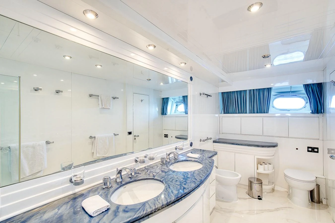 The yacht's bathroom features a luxurious double sink vanity with a marble countertop and ample lighting. aboard D-FORCE Yacht for Sale