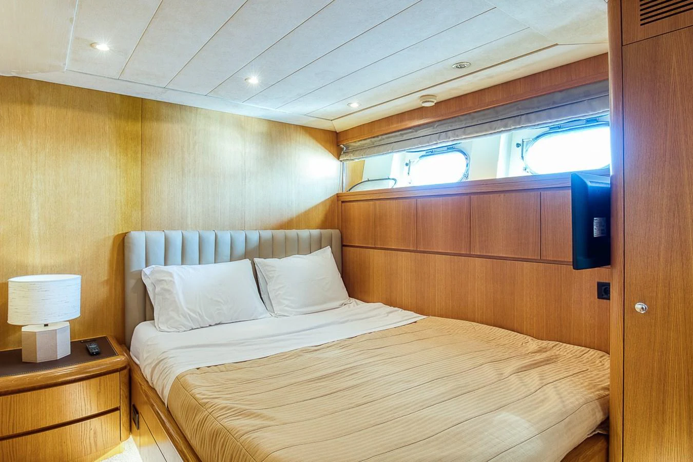 A cozy stateroom with a double bed and natural light from the windows. aboard D-FORCE Yacht for Sale