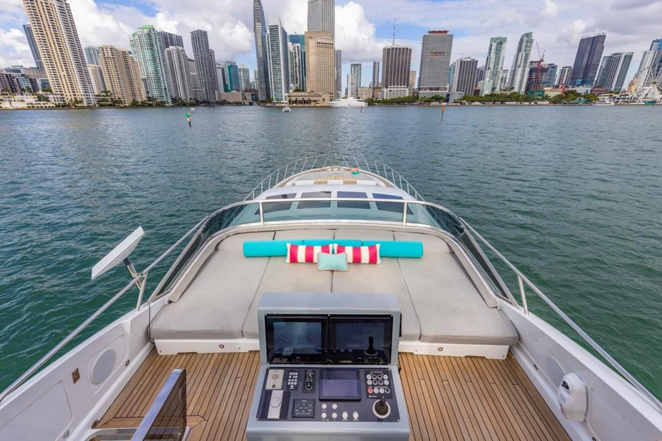 The bow of the yacht offers a spacious sunbathing area with a scenic city skyline in the background. aboard SAYONARA Yacht for Sale
