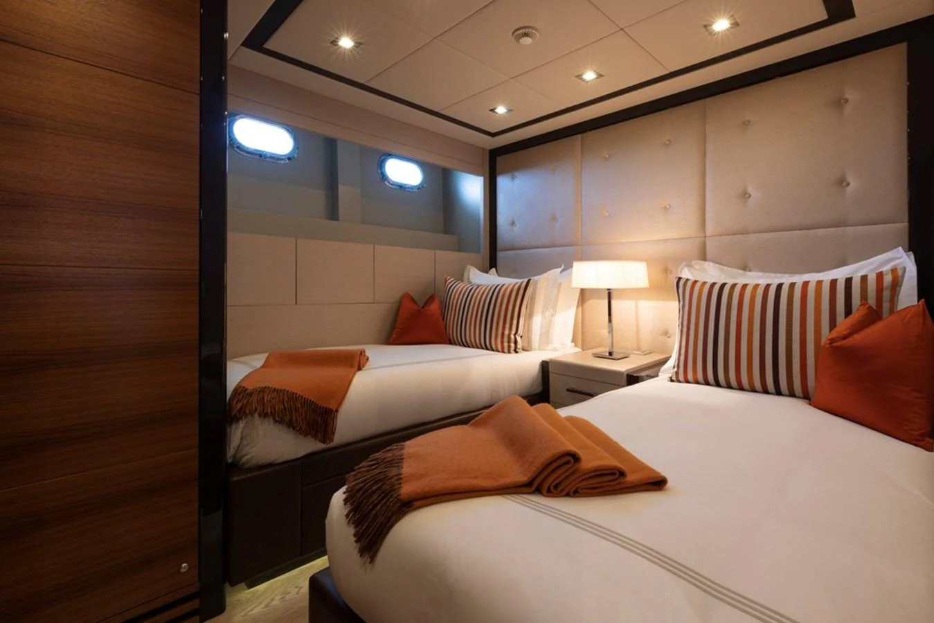 The guest stateroom features twin beds with elegant bedding and warm lighting. aboard SAYONARA Yacht for Sale