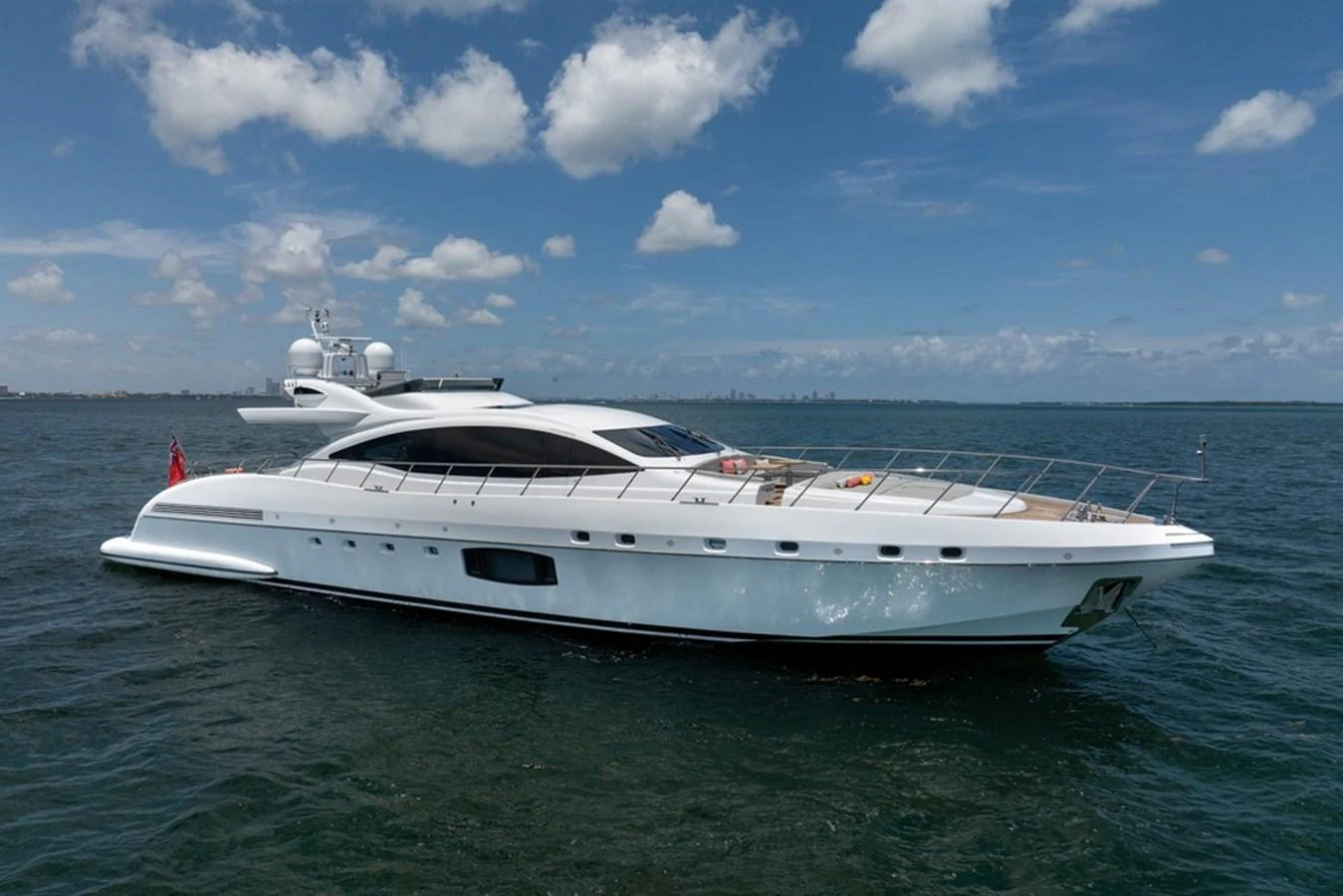 A sleek and modern yacht cruising on calm waters under a bright blue sky. aboard SAYONARA Yacht for Sale