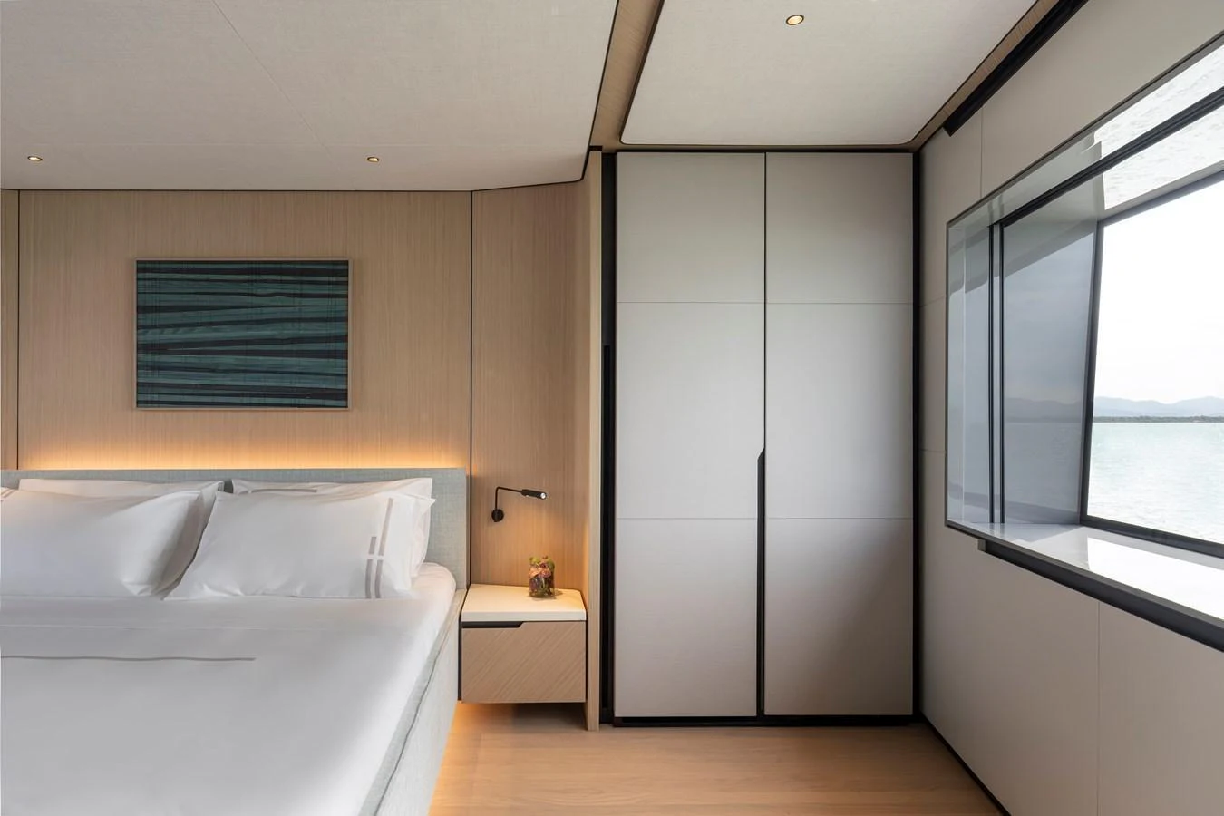A serene stateroom with a large bed, modern decor, and a view of the sea through a large window. aboard AZIMUT GRANDE 30M NEW Yacht for Sale