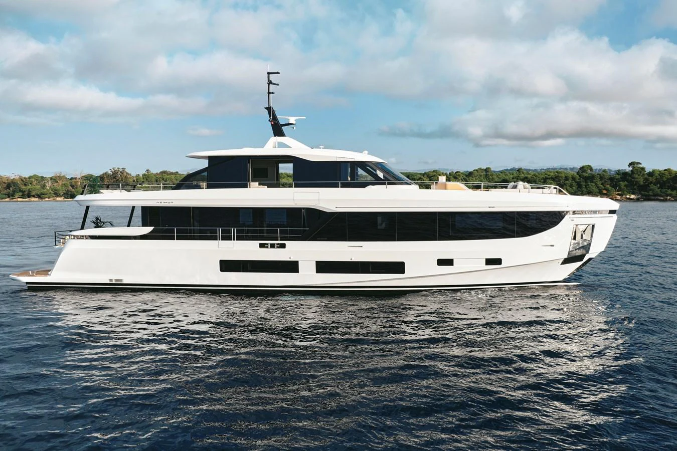 A sleek, modern yacht glides gracefully on calm waters under a partly cloudy sky. aboard AZIMUT GRANDE 30M NEW Yacht for Sale