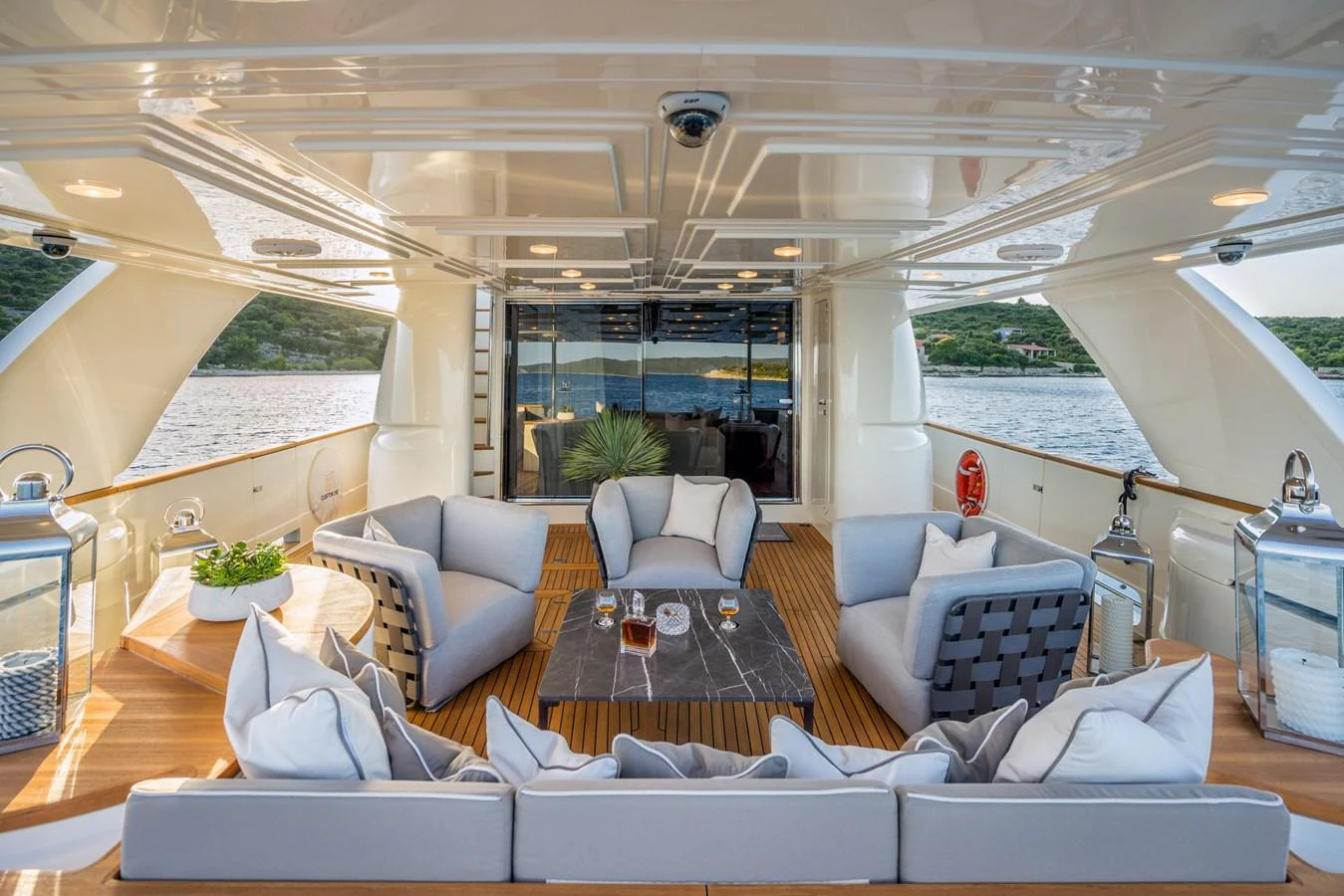 The aft deck features a stylish seating area with plush cushions and a central table, perfect for relaxing and enjoying the view. aboard SEVENTH SENSE Yacht for Sale