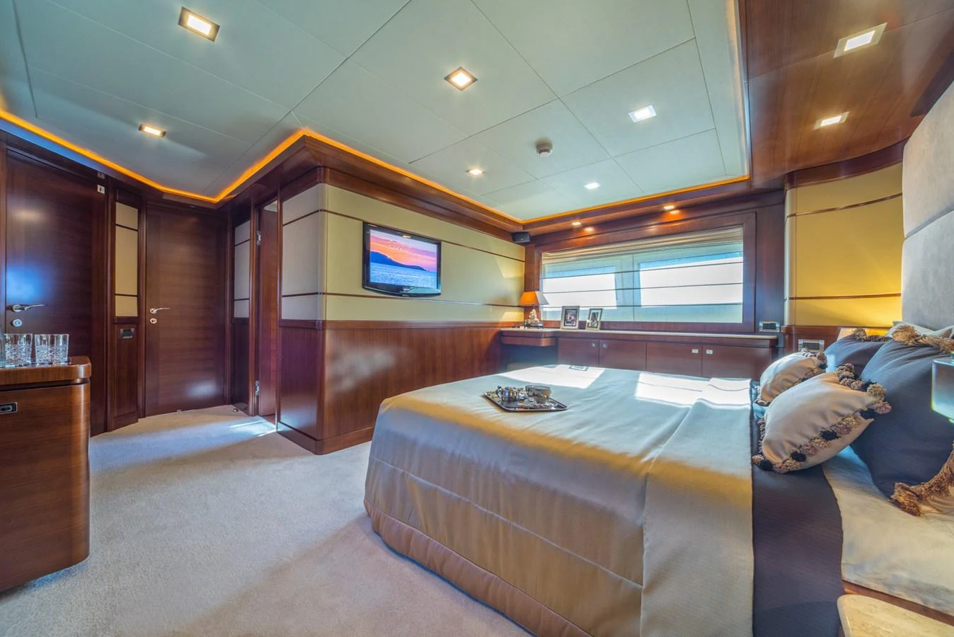 The master stateroom exudes luxury with its spacious layout, plush bedding, and elegant wood finishes. aboard SEVENTH SENSE Yacht for Sale