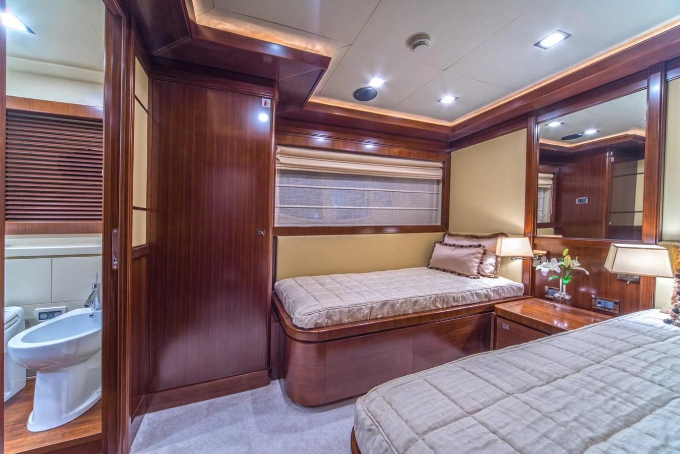 The guest stateroom offers a cozy and elegant retreat with twin beds and warm wood finishes. aboard SEVENTH SENSE Yacht for Sale