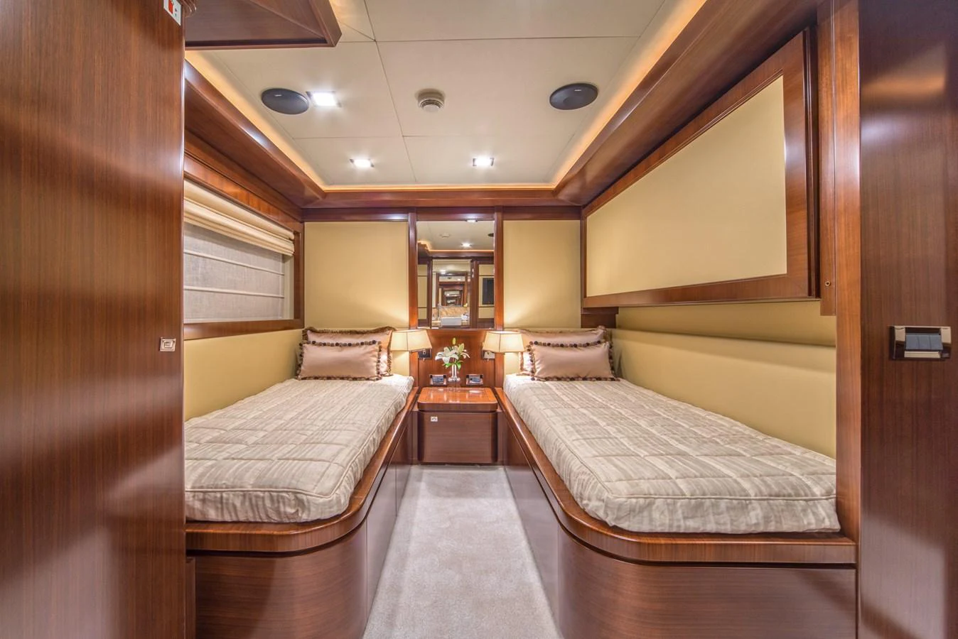 The twin stateroom features two single beds with elegant wood paneling and soft lighting. aboard SEVENTH SENSE Yacht for Sale