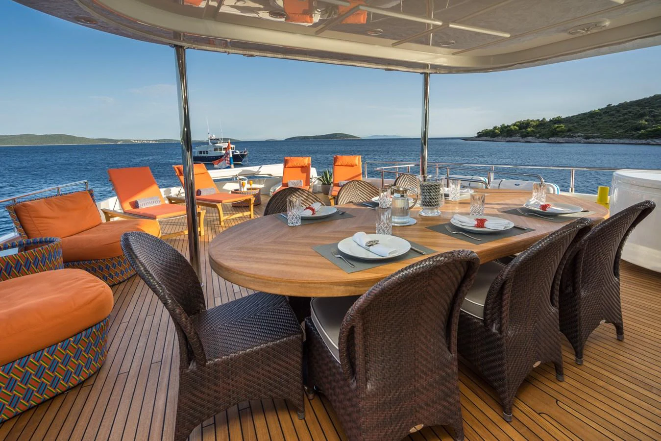 The aft deck features a stylish dining area with a beautiful view of the sea. aboard SEVENTH SENSE Yacht for Sale