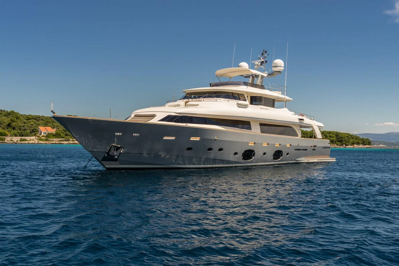 A sleek and modern yacht cruises gracefully on calm blue waters under a clear sky. aboard SEVENTH SENSE Yacht for Sale