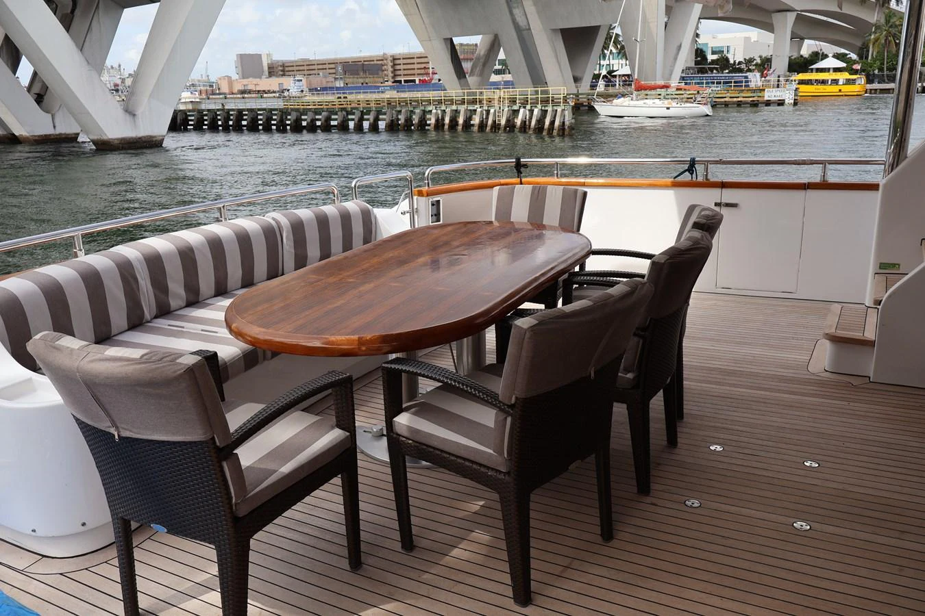 The aft deck features a stylish dining area with a wooden table and comfortable seating, perfect for alfresco meals. aboard Q Yacht for Sale