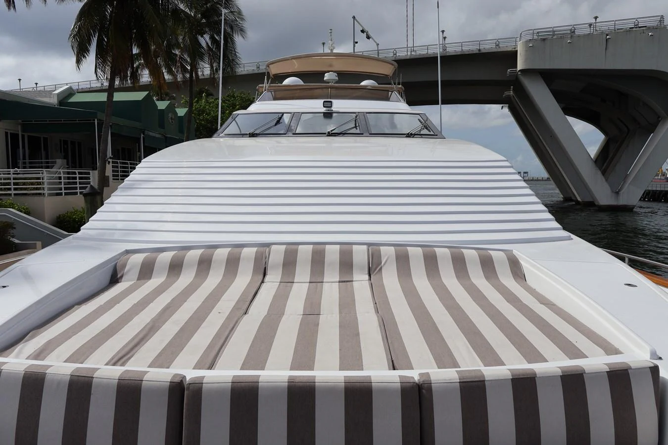 The yacht features a spacious and inviting sunbathing area with striped cushions, perfect for relaxation. aboard Q Yacht for Sale