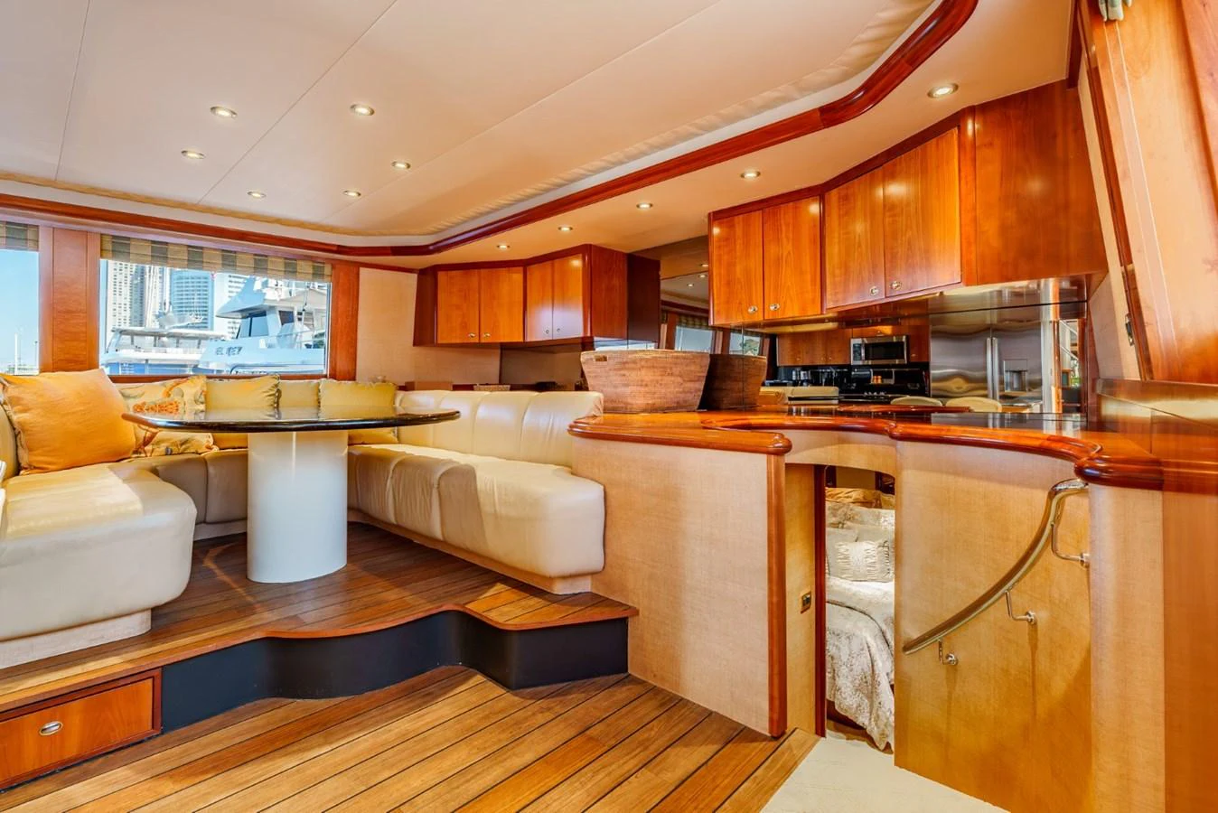 The yacht's salon features luxurious seating, a dining area, and a well-equipped galley with warm wood finishes. aboard SNOWBORED Yacht for Sale