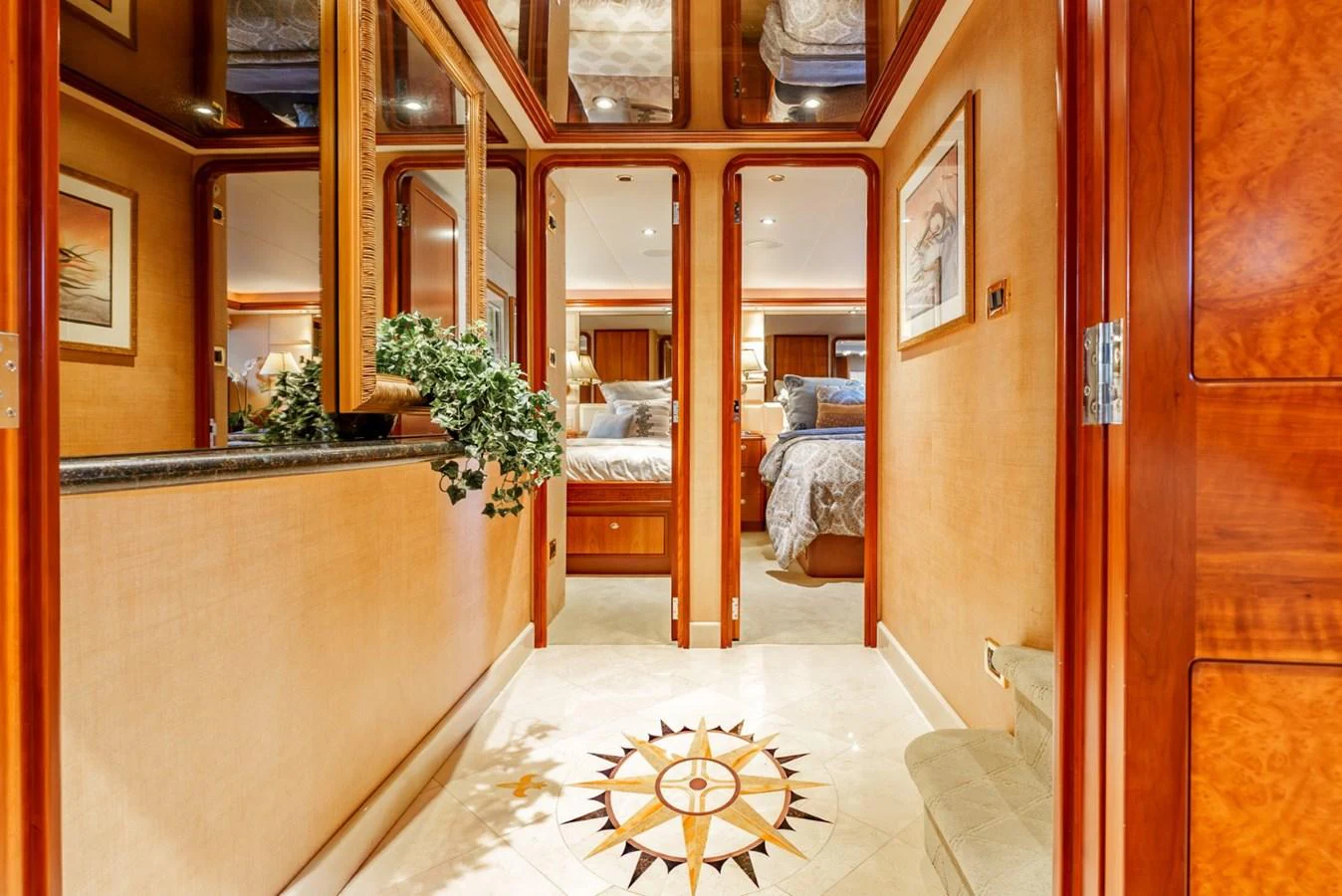 The yacht's interior features a luxurious hallway with elegant wood finishes and a decorative floor inlay. aboard SNOWBORED Yacht for Sale