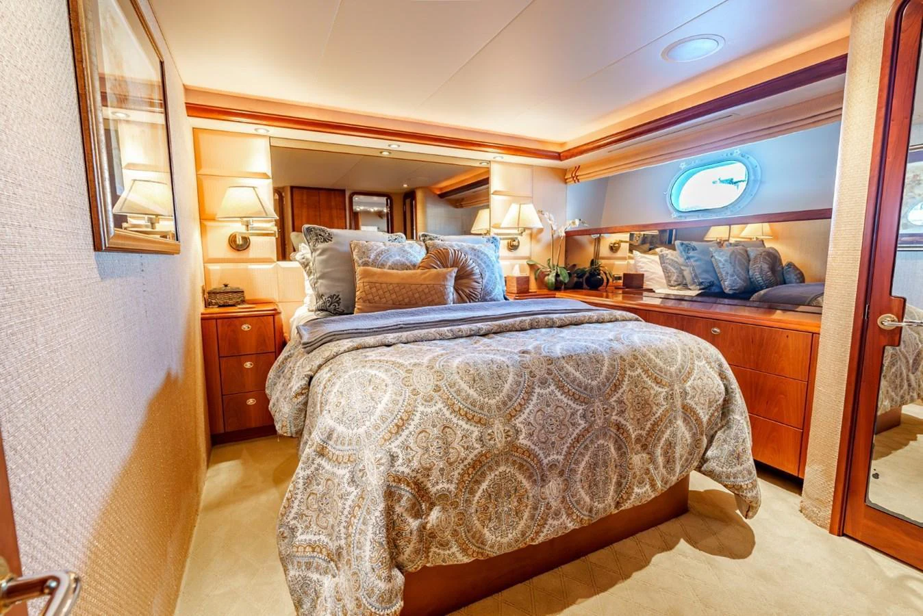 The stateroom features a plush bed with elegant bedding, warm wood finishes, and soft lighting for a cozy and luxurious atmosphere. aboard SNOWBORED Yacht for Sale