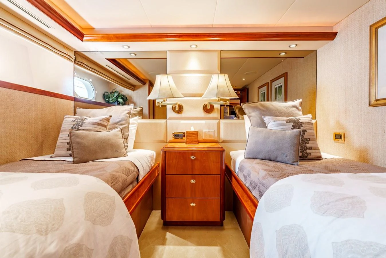The twin stateroom features two comfortable beds with elegant bedding and warm lighting. aboard SNOWBORED Yacht for Sale