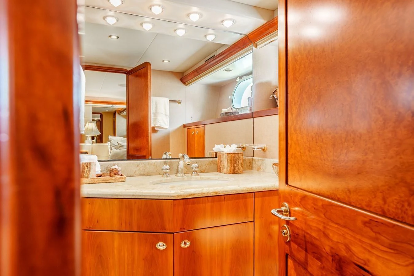 The yacht's bathroom features elegant wood cabinetry and a well-lit vanity area. aboard SNOWBORED Yacht for Sale