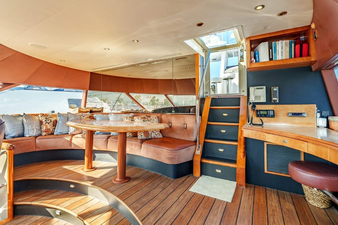The salon features a spacious seating area with plush cushions, a wooden table, and ample natural light. aboard SNOWBORED Yacht for Sale