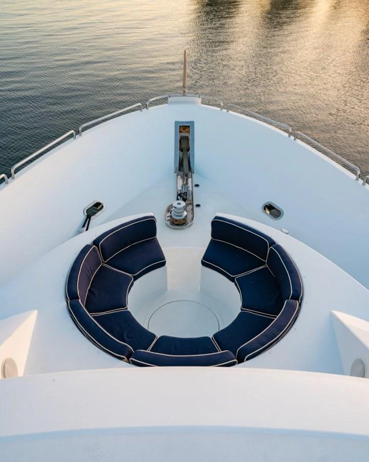 The yacht's bow features a cozy circular seating area with plush navy cushions, perfect for enjoying the view. aboard SNOWBORED Yacht for Sale