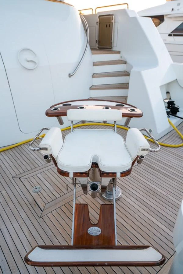 A well-crafted fishing chair is positioned on the deck, showcasing the yacht's sportfishing capabilities. aboard SNOWBORED Yacht for Sale