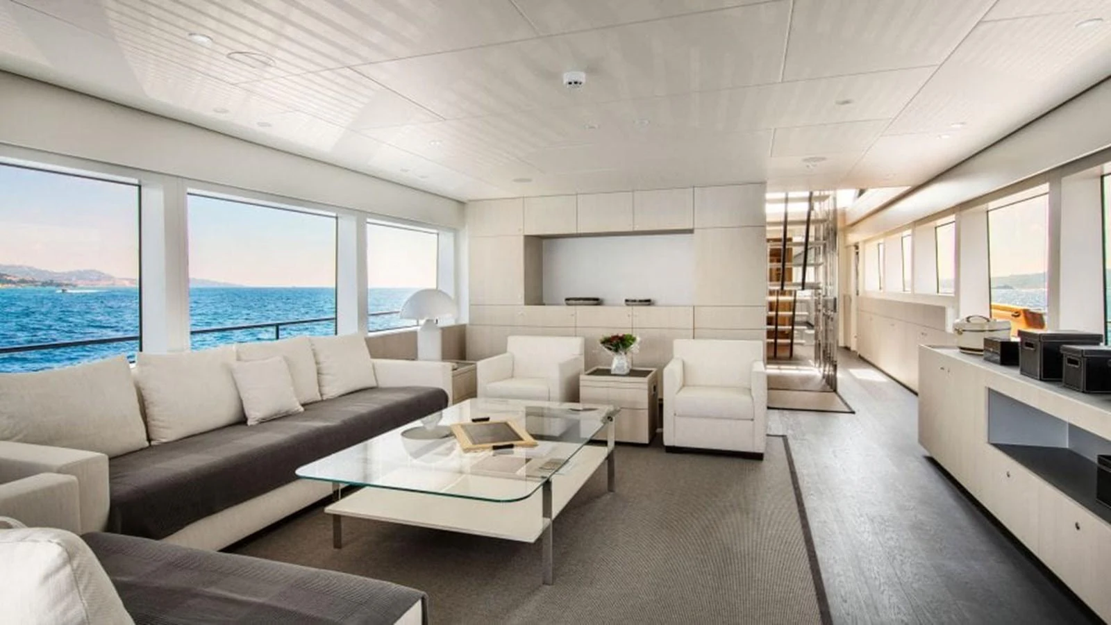 The spacious salon features modern furnishings and expansive windows offering stunning sea views. aboard JANGADA Yacht for Sale