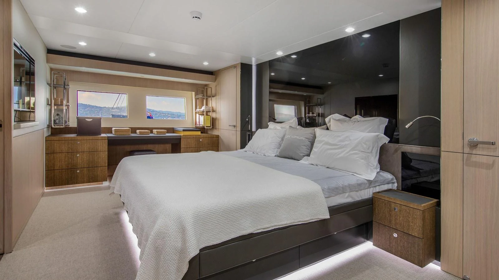 The master stateroom features a spacious bed, elegant wood finishes, and ample natural light. aboard JANGADA Yacht for Sale