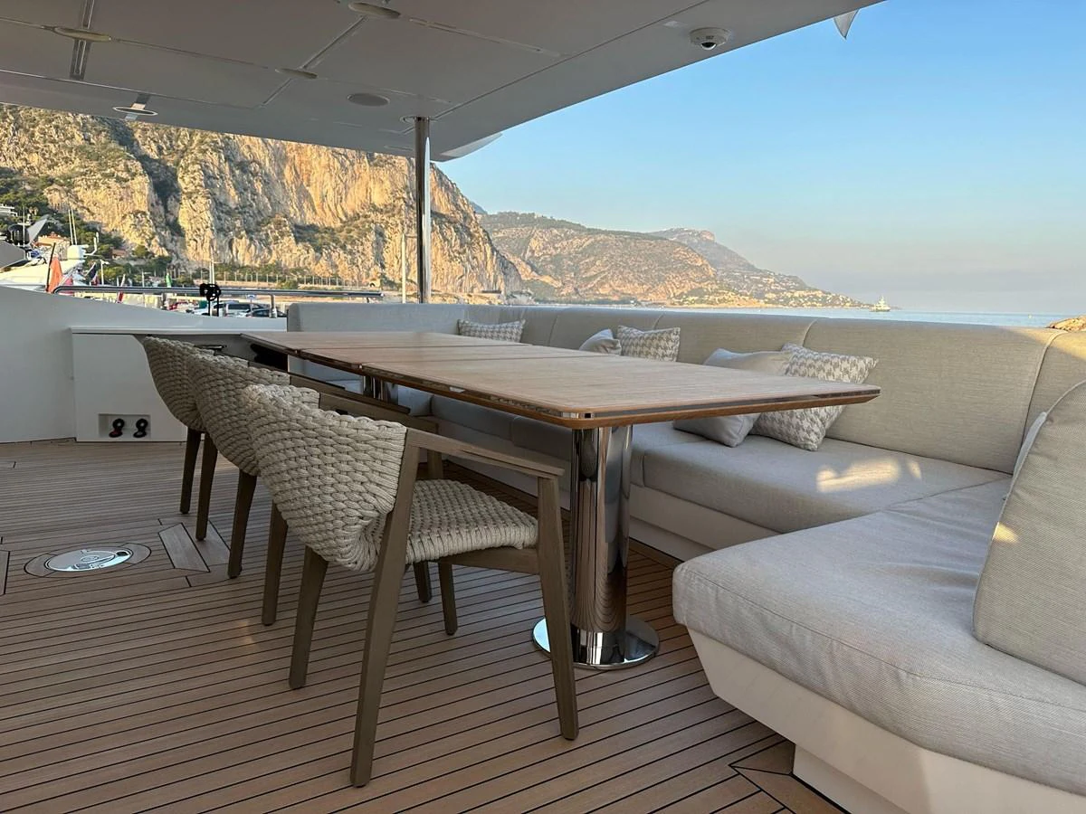 The aft deck features a comfortable seating area with a dining table, perfect for enjoying meals with a stunning view. aboard G Yacht for Sale