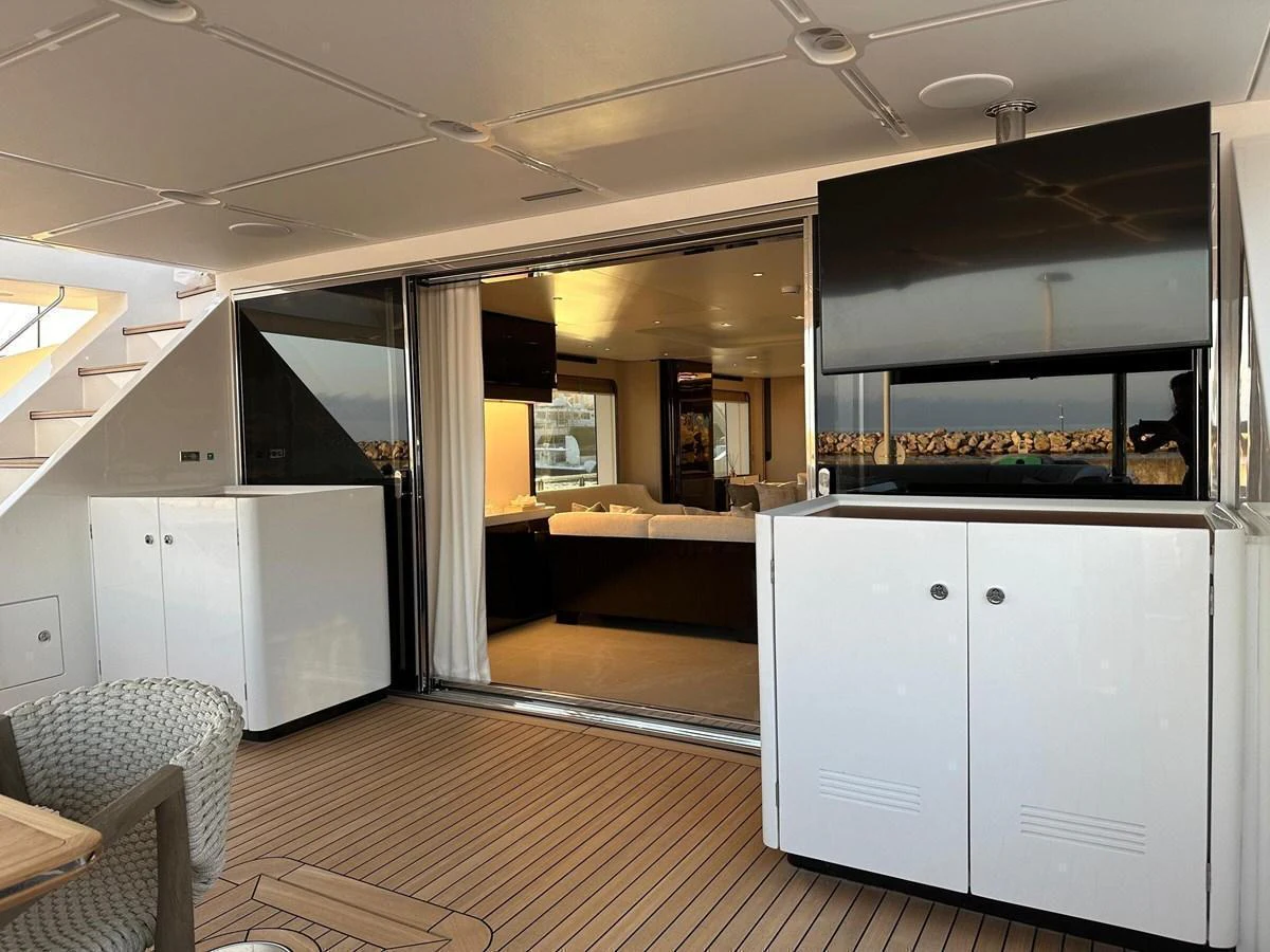 The image showcases the entrance to a luxurious salon area from the aft deck, featuring modern furnishings and ample natural light. aboard G Yacht for Sale