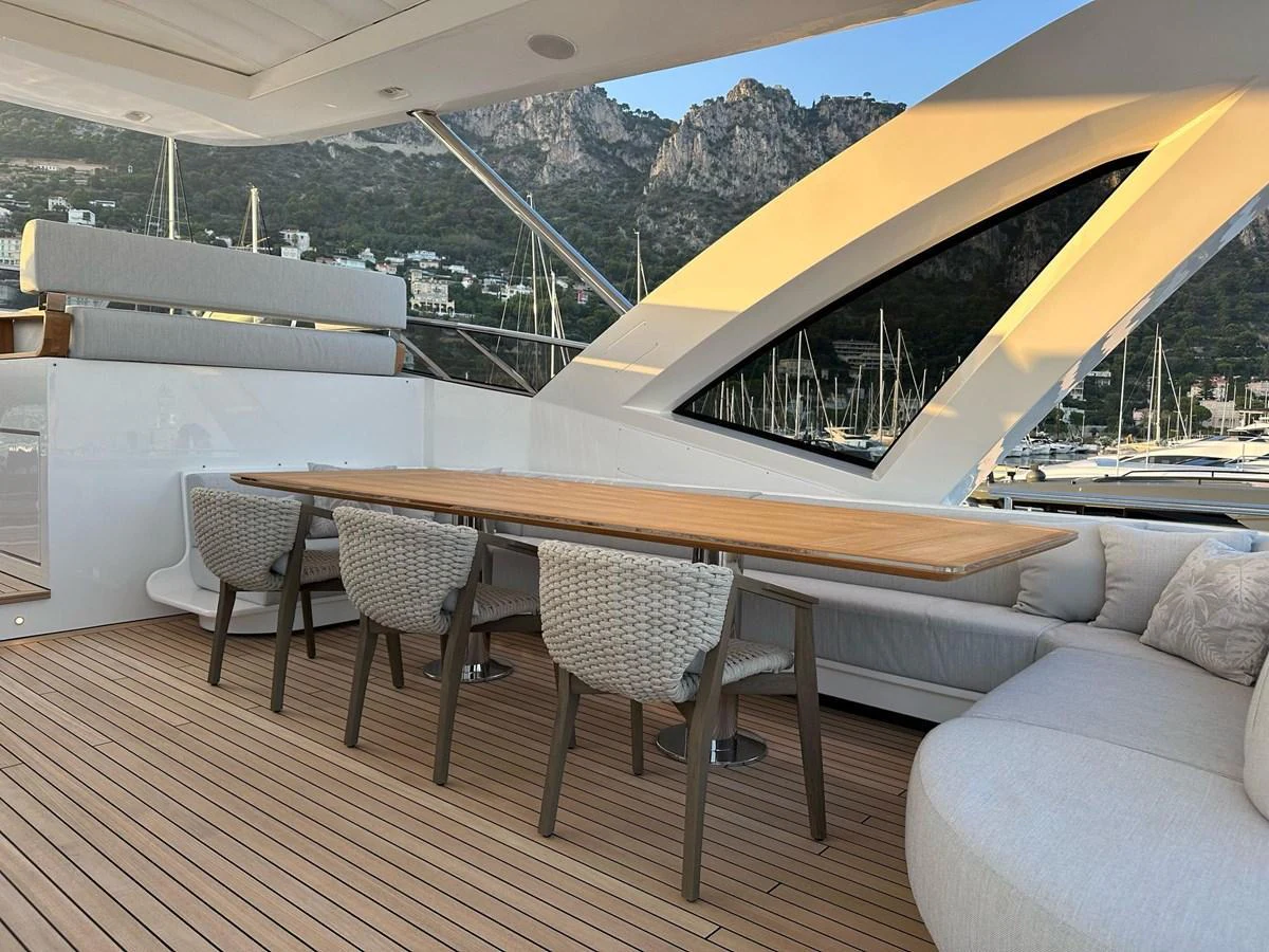 The aft deck features a stylish dining area with a wooden table and comfortable seating, perfect for alfresco meals. aboard G Yacht for Sale