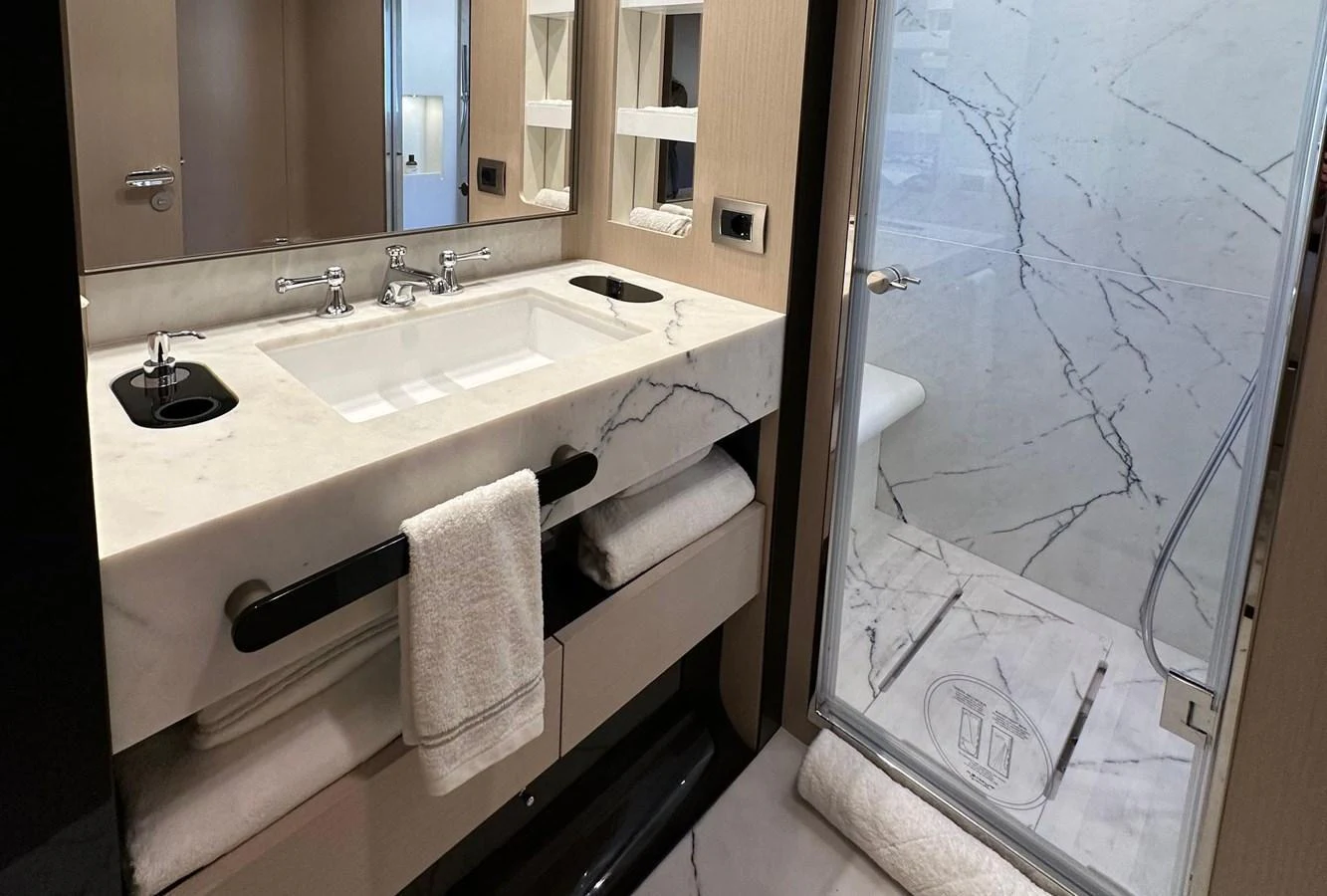 The yacht's bathroom features a sleek design with a marble countertop and a glass-enclosed shower. aboard G Yacht for Sale