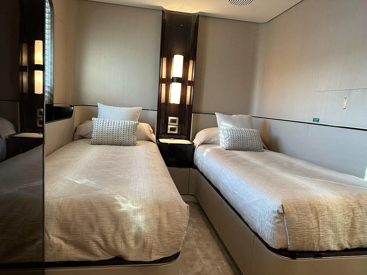 The twin stateroom offers a cozy and elegant sleeping area with two single beds and modern lighting. aboard G Yacht for Sale
