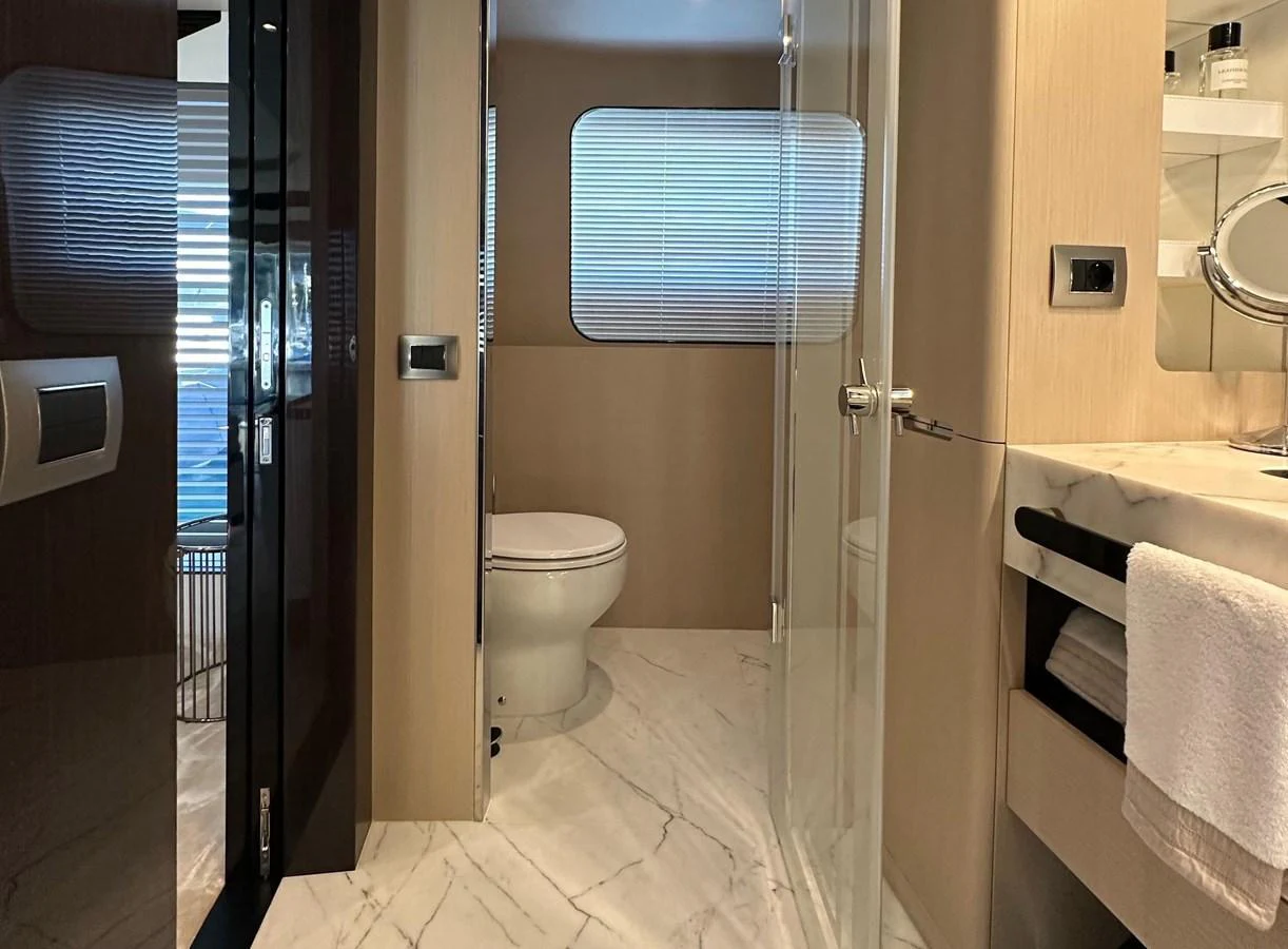 A sleek and modern yacht bathroom featuring a glass-enclosed shower and elegant marble flooring. aboard G Yacht for Sale