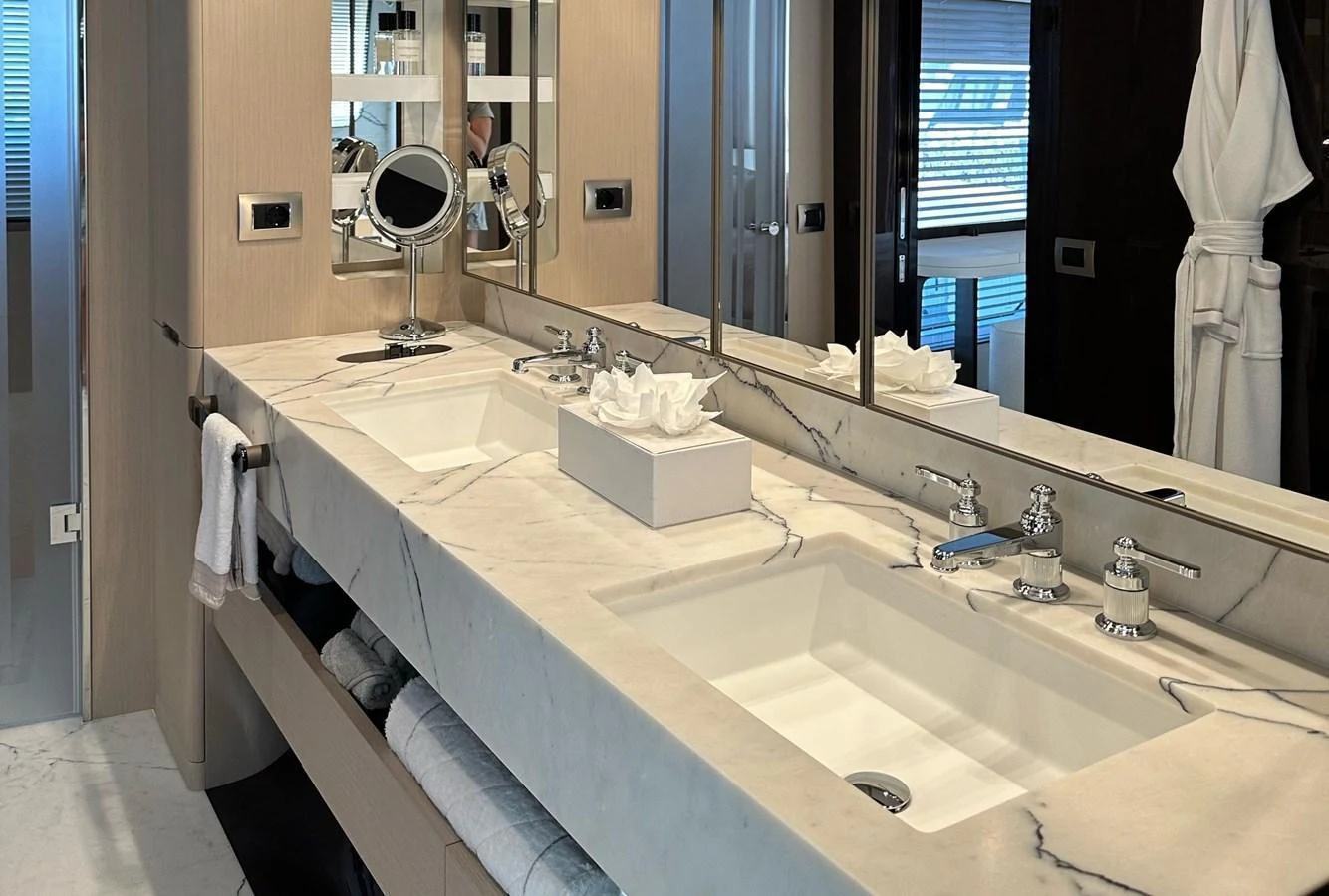 The yacht's bathroom features a luxurious double sink vanity with elegant fixtures and ample storage. aboard G Yacht for Sale