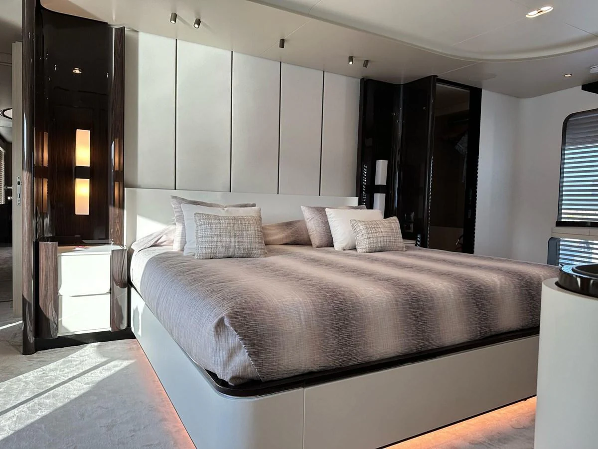 The master stateroom features a luxurious bed with modern decor and ambient lighting. aboard G Yacht for Sale