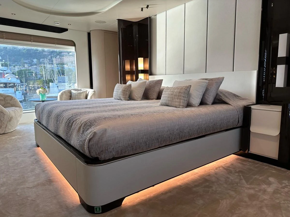 The master stateroom features a luxurious bed with ample natural light from large windows. aboard G Yacht for Sale