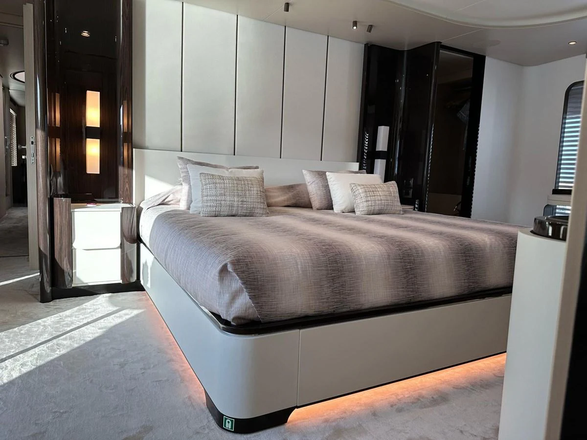 A luxurious stateroom featuring a large bed with elegant bedding and modern decor. aboard G Yacht for Sale