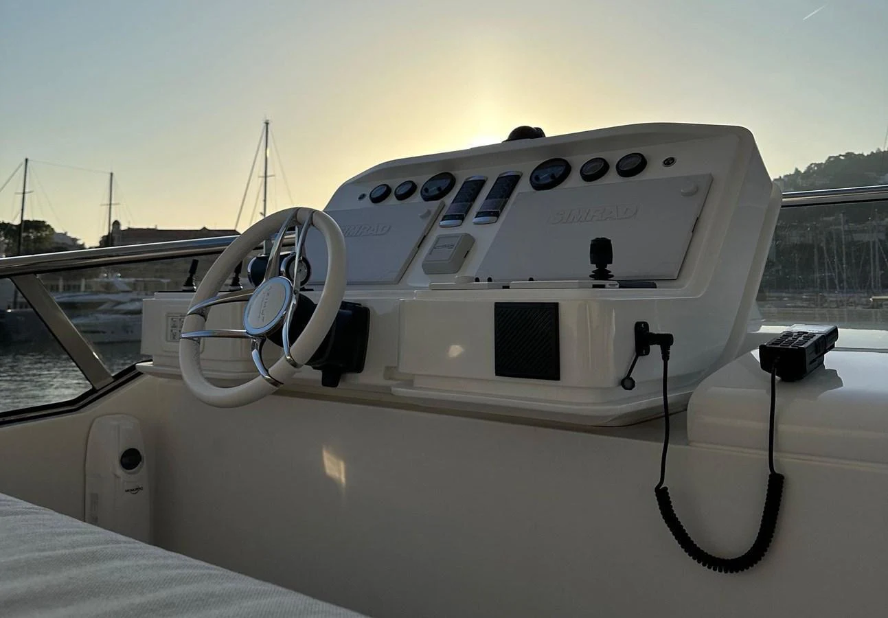 The helm station is bathed in the soft glow of the setting sun, highlighting its modern controls and sleek design. aboard G Yacht for Sale