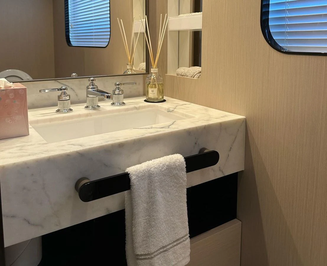 The yacht's bathroom features a sleek marble countertop with modern fixtures and a large mirror. aboard G Yacht for Sale