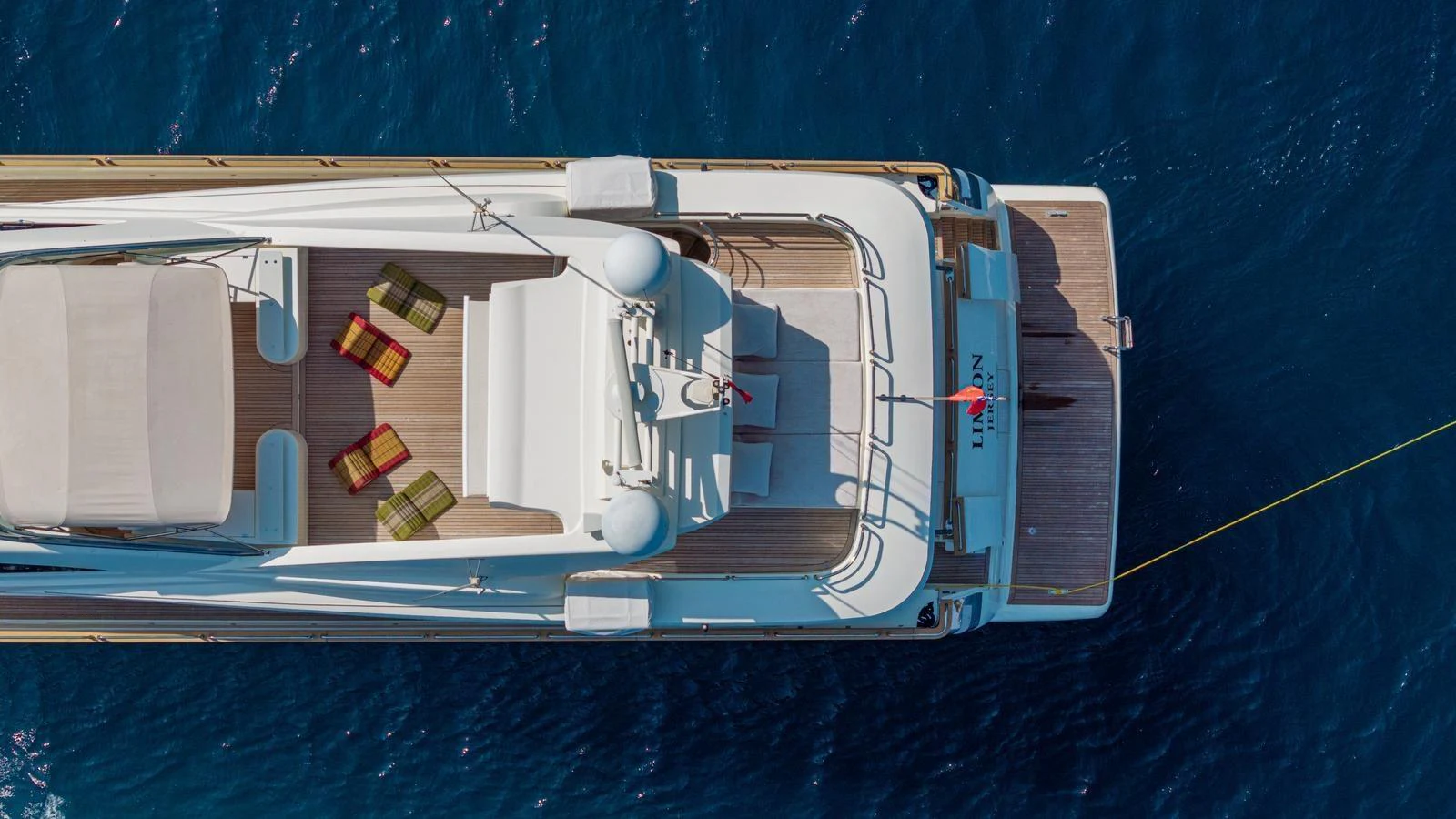 Aerial view of a yacht's sundeck with seating and lounging areas, floating on deep blue water. aboard LIMION Yacht for Sale