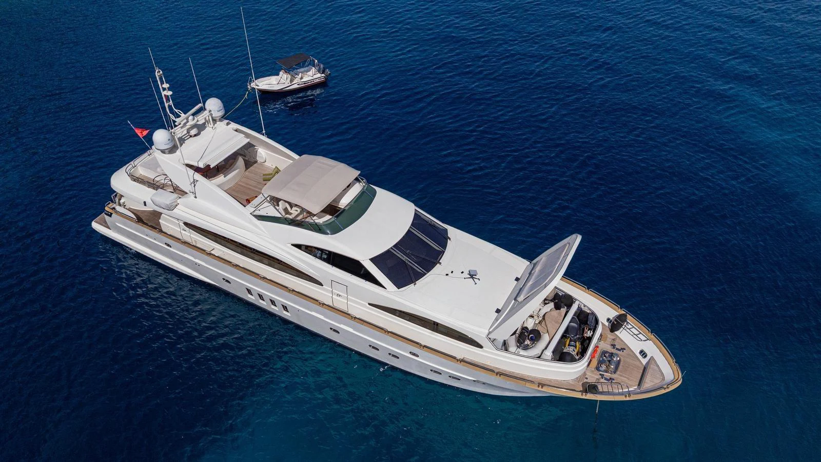 A sleek and modern yacht glides gracefully on the clear blue waters, showcasing its luxurious design and spacious deck. aboard LIMION Yacht for Sale
