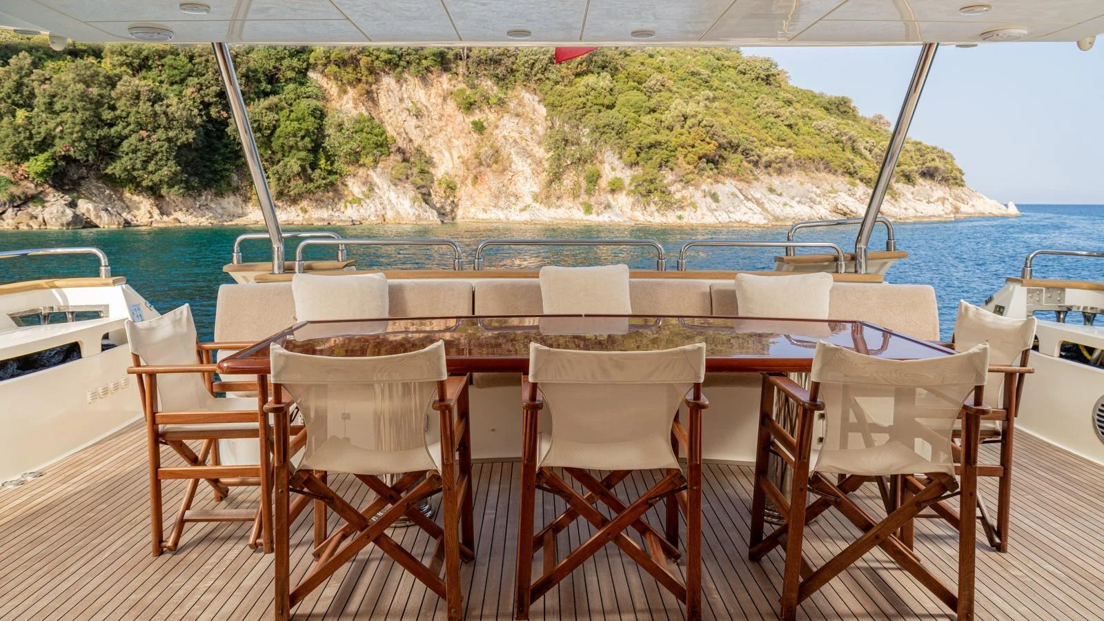The aft deck features a spacious dining area with a beautiful view of the surrounding landscape. aboard LIMION Yacht for Sale